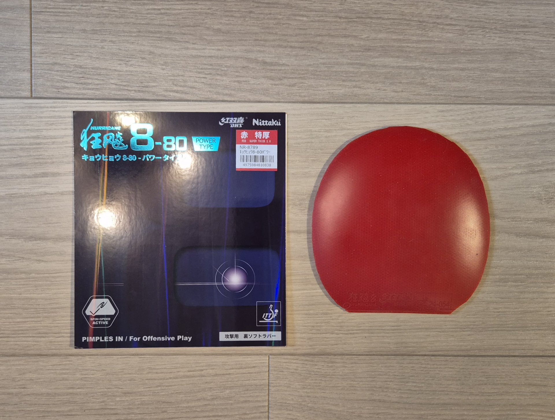 Nittaku Hurricane 8-80 Power rubber packaging and a cut red rubber sheet